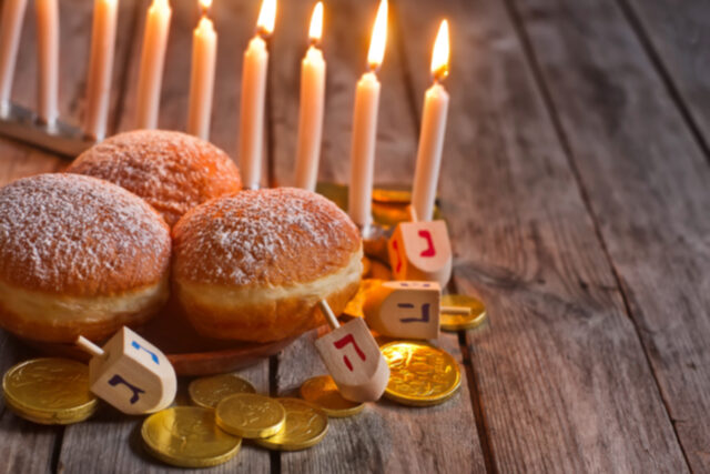 Menorah, doughnuts, chocolate coins and wooden dreidels